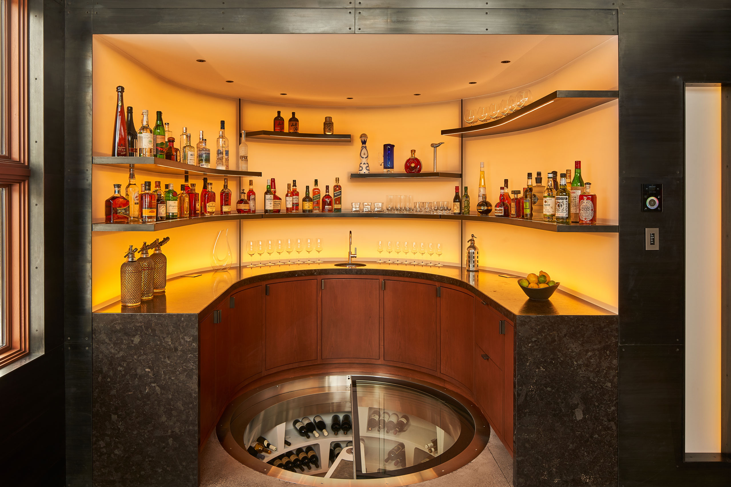 spiral wine cellar by Genuwine Cellars surrounded by bar area